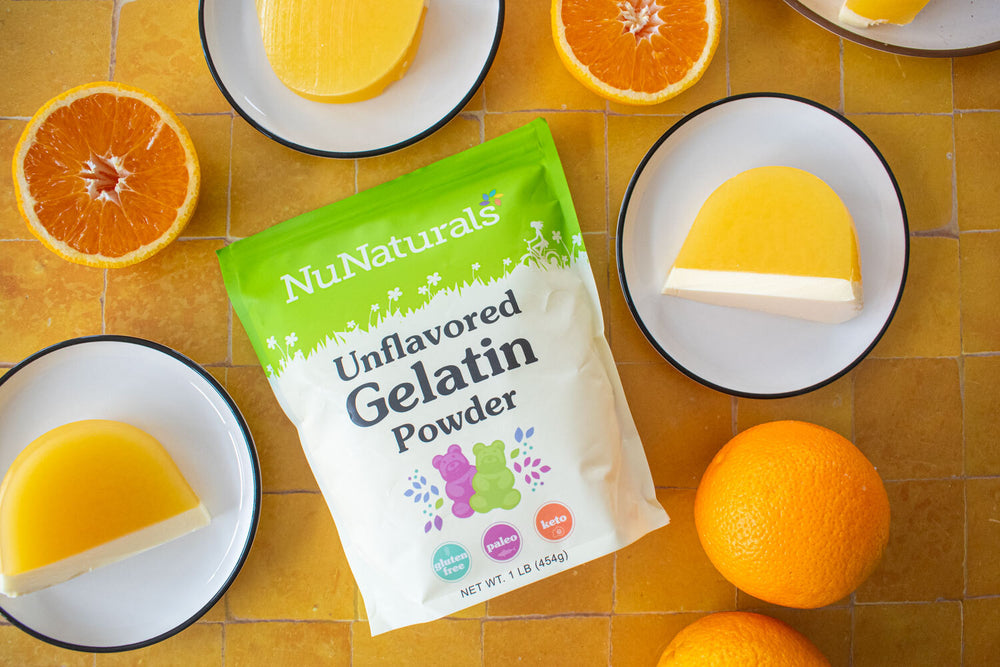 NuNaturels Unflavored Gelatin Powder package with Orange Creamsicle jelly mold desert.  Orange slices on a yellow surface