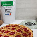 Bamboo Flour pouch behind a lattice cherry pie on a white counter