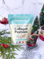 Collagen peptides pouch with red berry cocktails, small holiday trees and evergreen sprigs around it