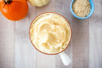 Bowl of whipped topping sprinkled with yellow flakes, beside a small bowl of yeast flakes