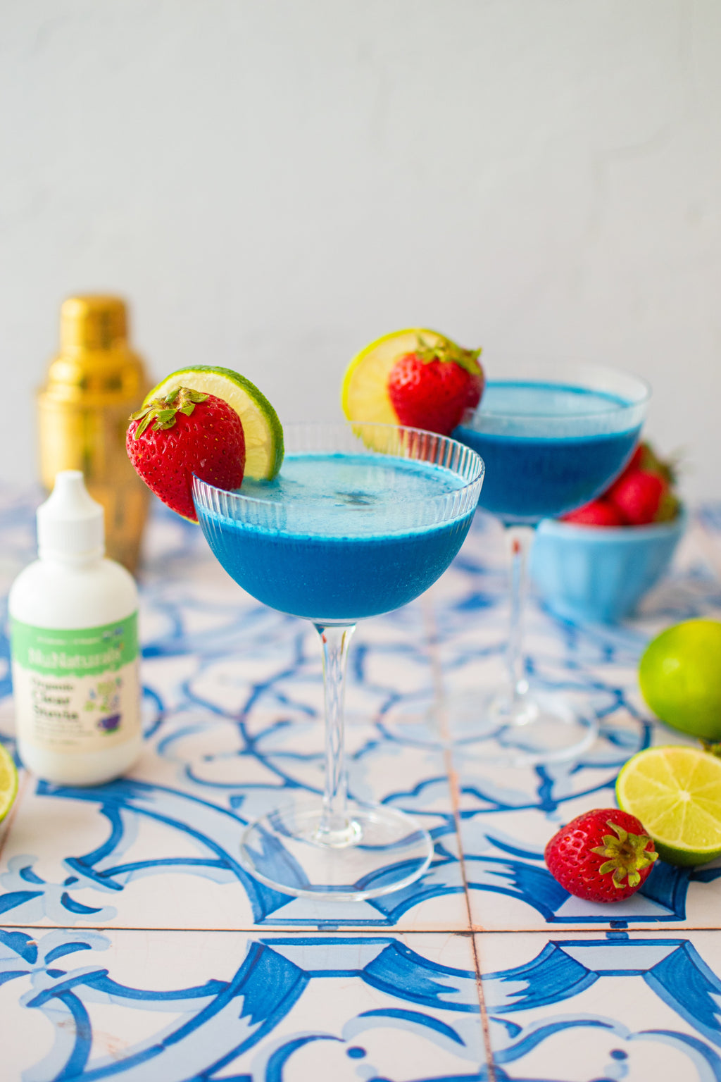 Organic Clear Extract Stevia 4 oz bottle beside a blue cocktail in a coupe glass garnished with strawberry and lime