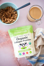 Organic Collagen pouch, front label, on a pink marble surface beside a bowl of granola and a glass mug of coffee