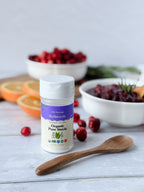 Organic Pure Stevia shaker jar with cranberries, orange halves, a bowl of cranberry sauce, and a wooden spoon