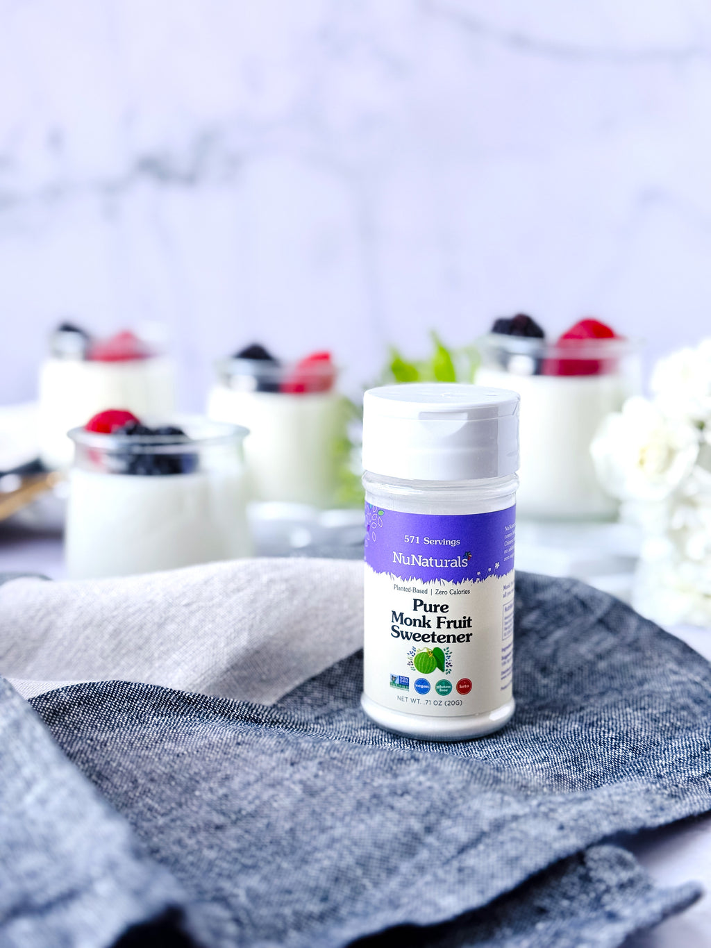 Pure Monk Fruit Sweetener .71 oz shaker with small glass dishes of yogurt and berries behind it