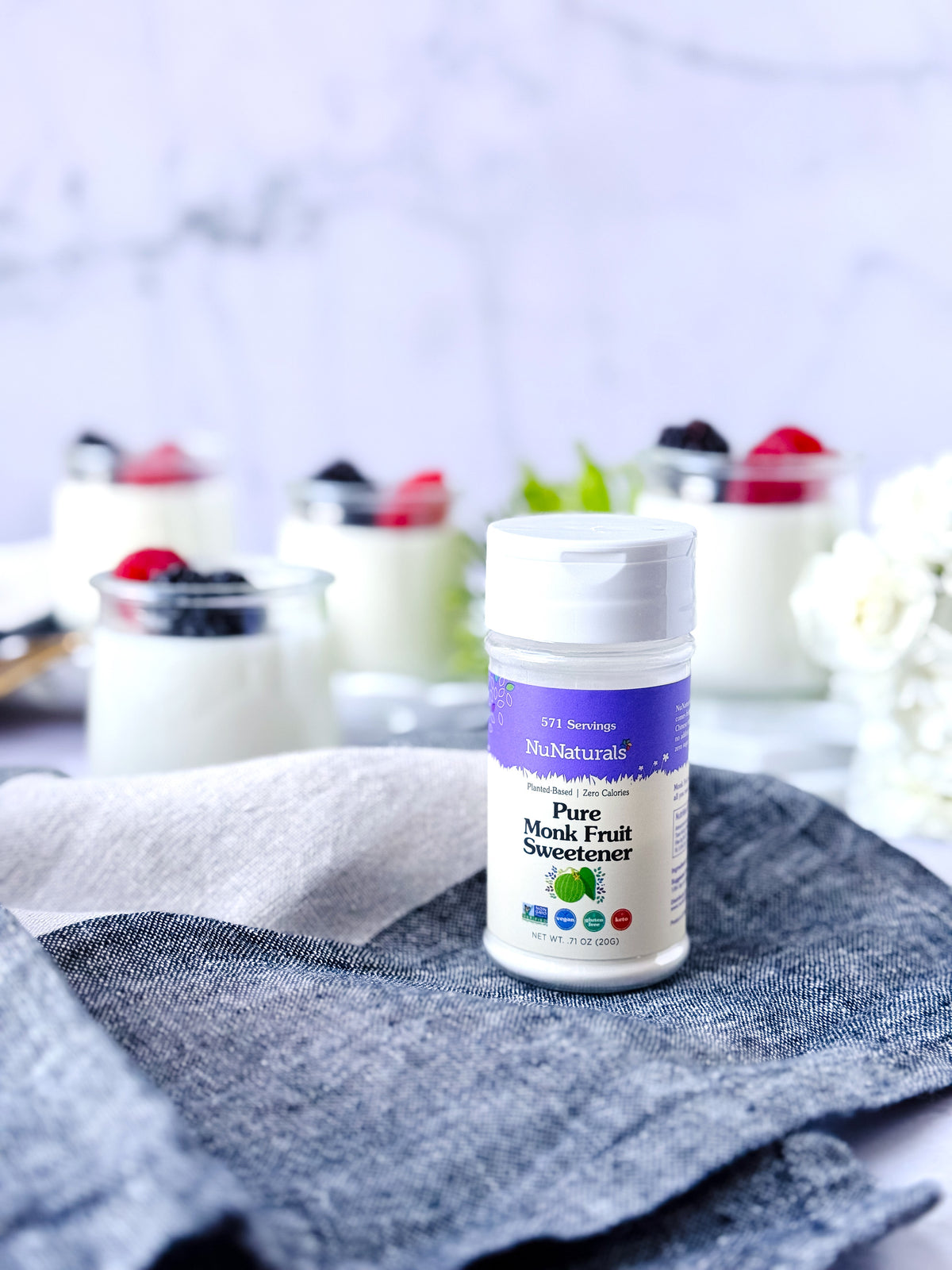 Pure Monk Fruit Sweetener .71 oz shaker with small glass dishes of yogurt and berries behind it