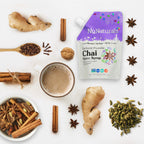 Chai Spice Syrup 6.6 oz pouch surrounded by ginger, cinnamon sticks, star anise, cloves and cardamom, next to a mug of chai