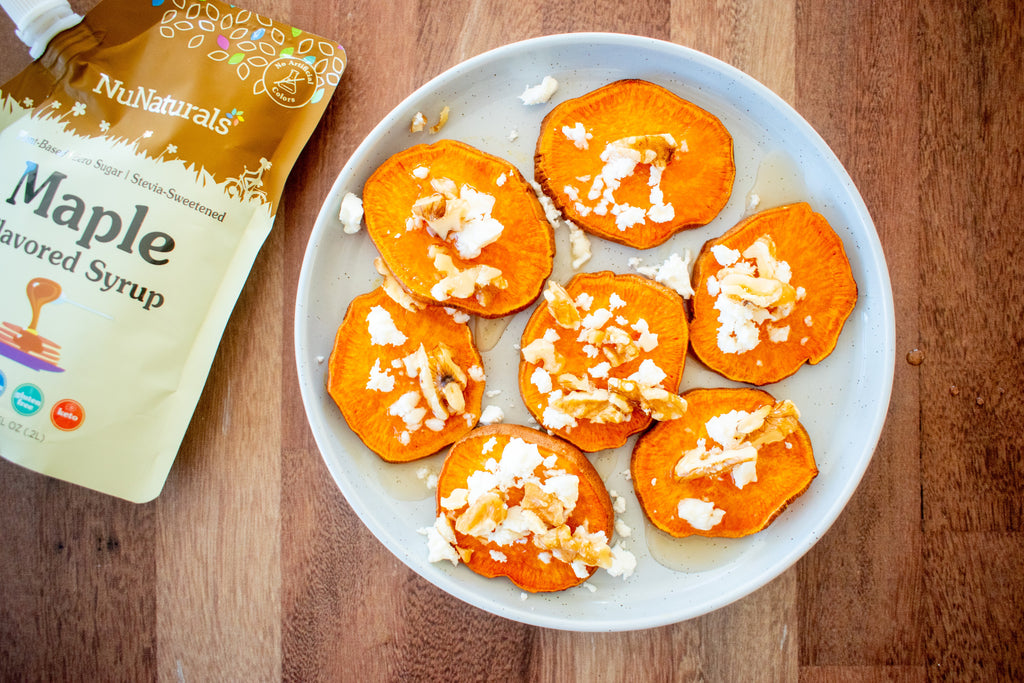 Maple Flavored Syrup 6.6 oz pouch edge beside a plate of sliced sweet potato rounds with nuts and white crumbles