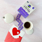 White Stevia Powder Blend Packets box and loose packets beside a coffee cup and a heart card in a red envelope