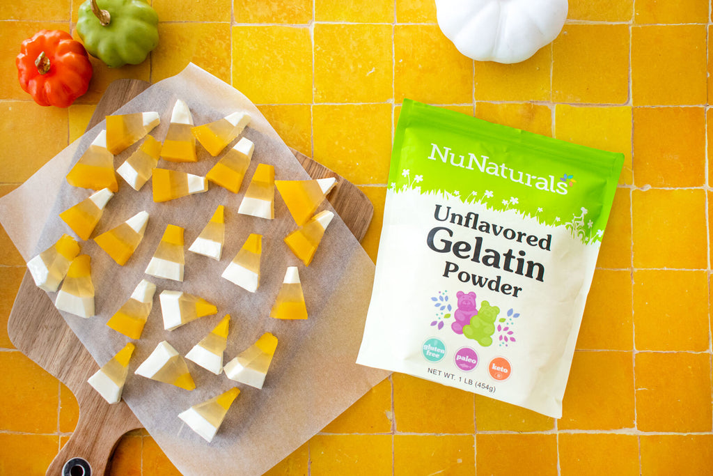 Unflavored Gelatin bag beside two-tone candy corn shaped gummies on parchment paper over yellow tile