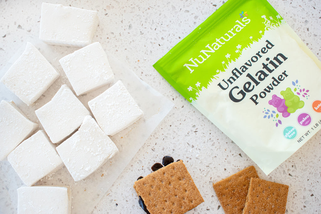 Unflavored Gelatin pouch cropped at the edge, beside square marshmallows and graham crackers on a speckled counter