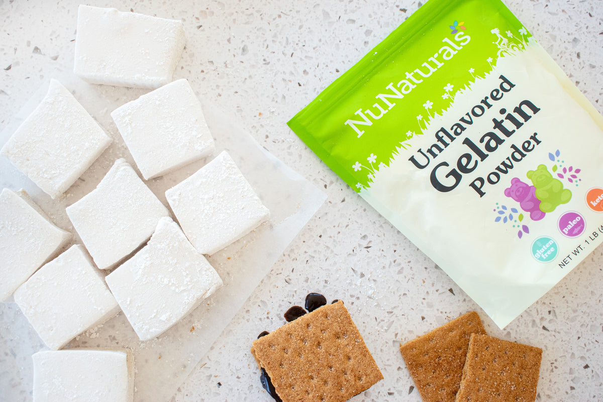 Unflavored Gelatin pouch cropped at the edge, beside square marshmallows and graham crackers on a speckled counter
