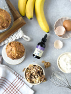 Vanilla Alcohol-Free Stevia 2 oz dropper bottle among banana muffins, bananas, walnuts, eggs and flour, seen from above